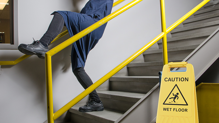 Darstellung einer Treppe, die eine potenzielle Gefahrensituation für einen Betriebsunfall darstellt. Mitarbeiter rutscht fast aus. Darstellung einer Treppe, die eine potenzielle Gefahrensituation für einen Betriebsunfall darstellt. Mitarbeiter rutscht fast aus.