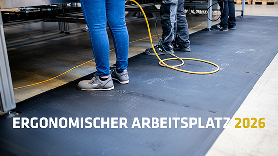 Mitarbeitende stehen an einem industriellen Arbeitsplatz auf einer ergonomischen Arbeitsplatzmatte. Sichtbar sind Beine und Arbeitsschuhe, Kabel verlaufen über den Boden. Text im Bild: ‚Ergonomischer Arbeitsplatz 2026‘ Mitarbeitende stehen an einem industriellen Arbeitsplatz auf einer ergonomischen Arbeitsplatzmatte. Sichtbar sind Beine und Arbeitsschuhe, Kabel verlaufen über den Boden. Text im Bild: ‚Ergonomischer Arbeitsplatz 2026‘